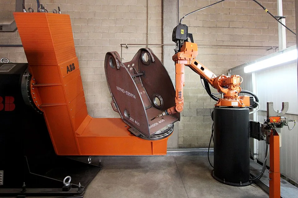 Industrial robot arm handling a heavy metal part